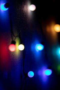 Colorful string lights creating a vibrant glow against a dark background, perfect for festive themes.