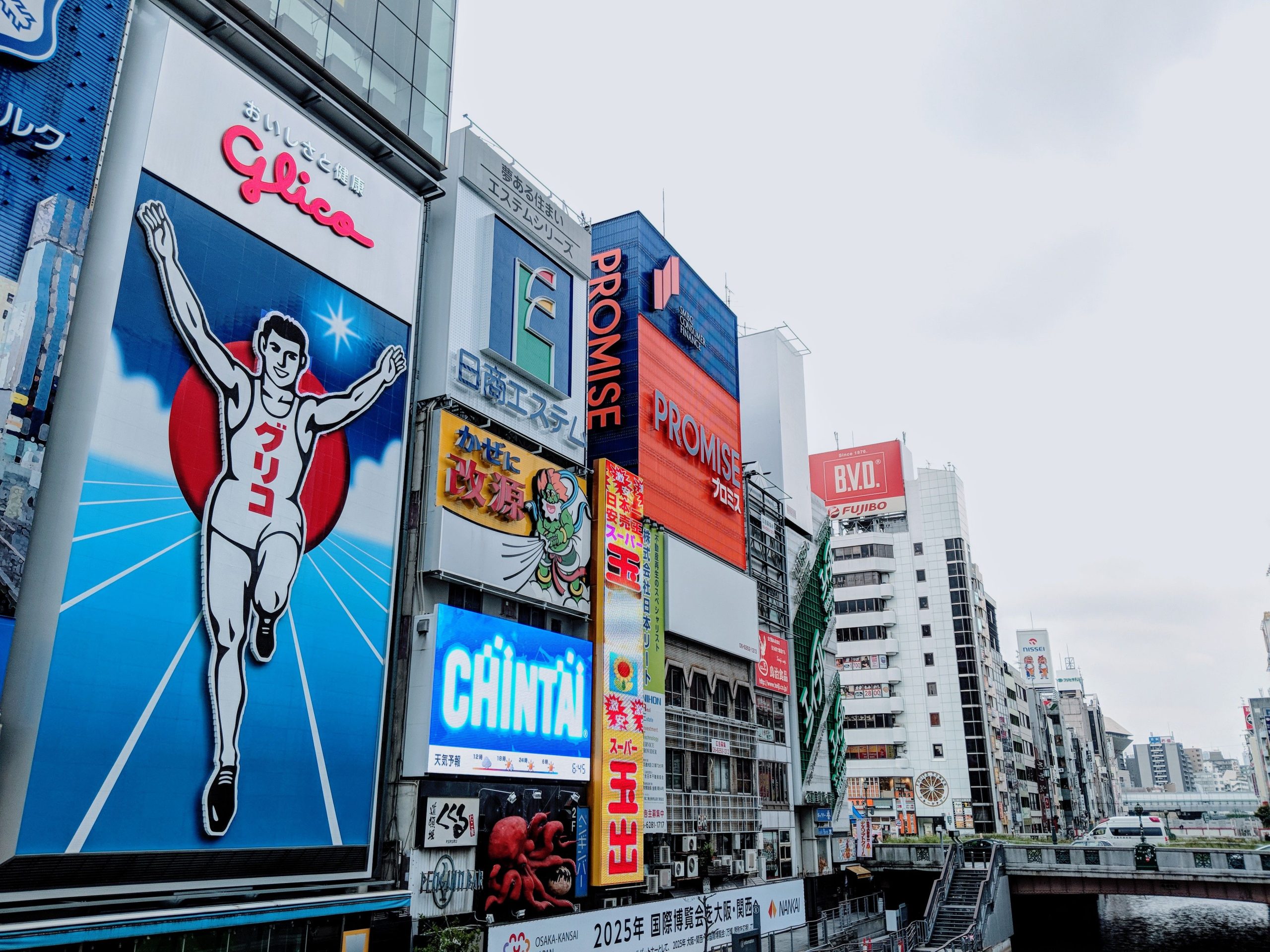 Vibrant advertisements in Dotonbori district, Osaka capturing the lively urban scene with the famous Glico Man sign.